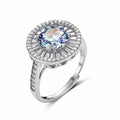 Close-up of sterling silver halo ring with round rainbow moissanite center stone surrounded by baguette-cut stones