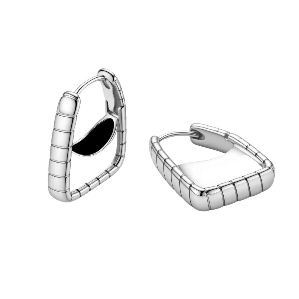 Close-up of platinum-plated sterling silver hoop earrings with horizontal textured grooves on white background.