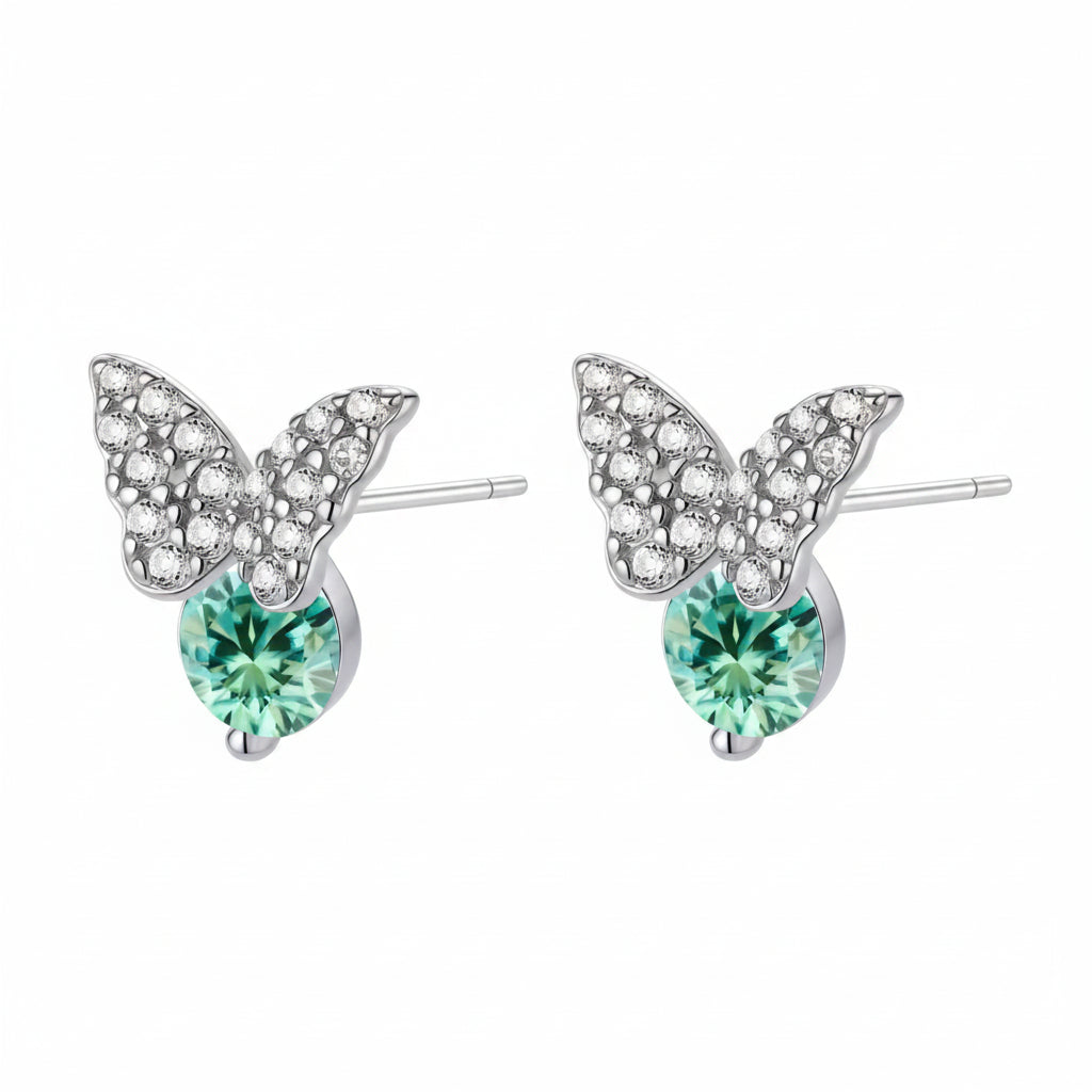 Sterling silver butterfly stud earrings with crystal wings and mint green center stones on cream background.