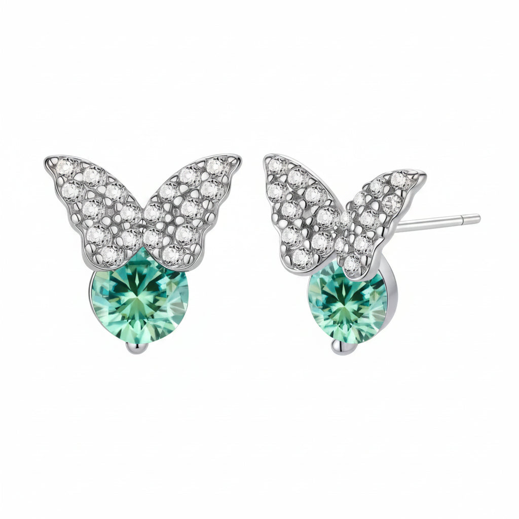 Sterling silver butterfly stud earrings with crystal wings and mint green center stones on cream background.