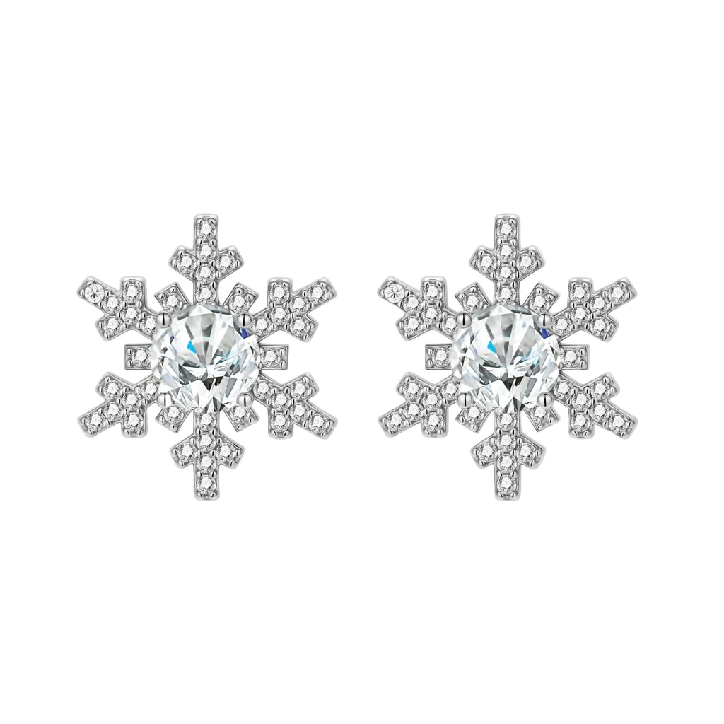 Sterling silver snowflake stud earrings with brilliant moissanite centers and intricate geometric patterns on cream background