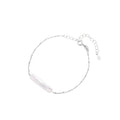 Minimalist bracelet with iridescent baroque pearl on rhodium-plated sterling silver chain against cream background