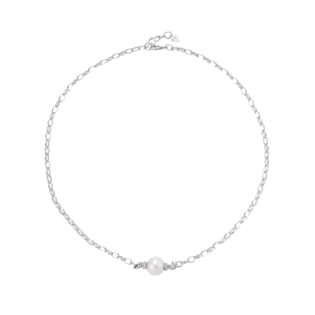 Dainty rhodium-plated silver chain necklace with centered 10mm freshwater pearl and crystal accents on cream background